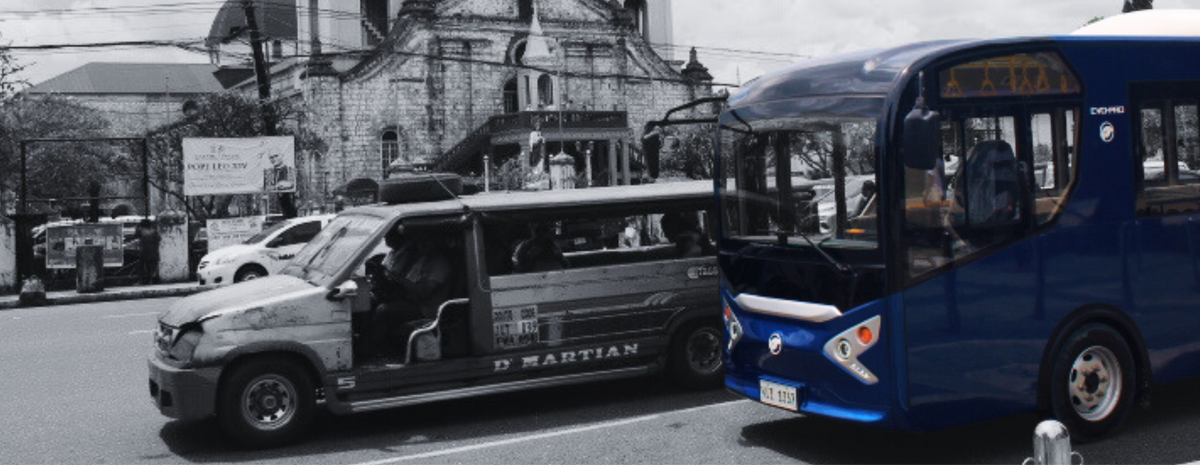 EVO-PRO electric minibus operating alongside a traditional Philippine public utility vehicle